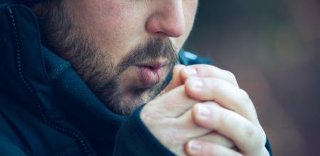 Man blowing in his hands, cold weather