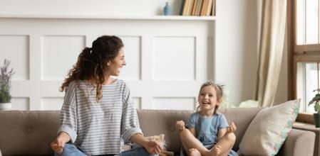 Beautiful pshychologist and toddler doing therapy with emotions emoji around lots of toys at kindergarten