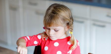 Relaxed young family with cute children sitting and meditating with closed eyes. Attractive wife and husband with son and daughter do breathing exercises. Parents with kids doing yoga together.
