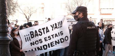 Agentes de Policía Nacional escoltan la manifestación convocada ante el Consolat de Mar donde varias personas sostienen una pancarta con el lema 
