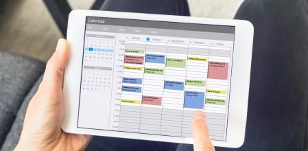 Calendar app on tablet computer with planning of the week with appointments, events, tasks, and meeting. Hands holding device, time management concept, organization of working hours planner, schedule (Calendar app on tablet computer with planning of t