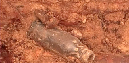 Botella hallada en una fosa común