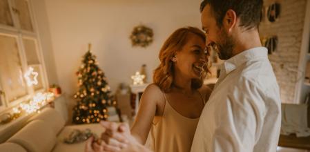 Pareja baila con las luces de Navidad de fondo