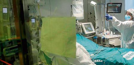 GRAFCAT7200. BARCELONA, 19/01/2021.- Profesionales sanitarios trabajan en una de las UCI del Hospital Clínic de Barcelona para pacientes covid, este martes, cuando los indicadores epidémicos en Cataluña han vuelto a mejorar por segundo día consecutivo, aunque el número de pacientes en las UCI aún aumenta y ya se ha situado en cifras similares al pico de la segunda ola, con 590 pacientes graves de COVID, 40 más que ayer. EFE/Toni Albir