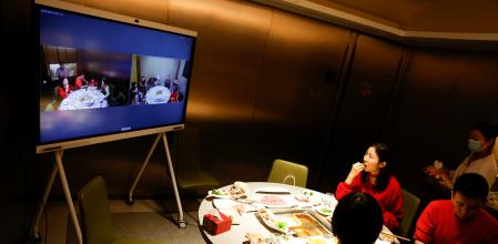 Liu Yuting and her family enjoy Chinese Lunar New Year dinner at a Haidilao hotpot restaurant with relatives in Jilin province connected via video link after they decided not to travel to their hometown following authorities advice after an outbreak of the coronavirus disease (COVID-19), in Beijing, China February 11, 2021. REUTERS/Carlos Garcia Rawlins