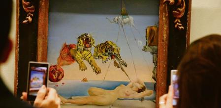 ST PETERSBURG, RUSSIA - OCTOBER 28, 2016: Visitors take photographs of Salvador Dali's Dream Caused by the Flight of a Bee on display at an exhibition titled 