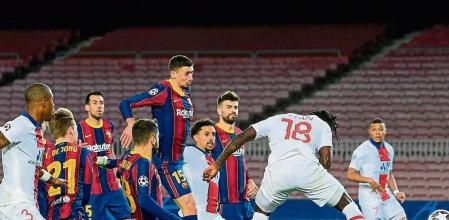 TOPSHOT - Paris Saint-Germain's Italian forward Moise Kean (R) scores a header during the UEFA Champions League round of 16 first leg football match between FC Barcelona and Paris Saint-Germain FC at the Camp Nou stadium in Barcelona on February 16, 2021. (Photo by LLUIS GENE / AFP)