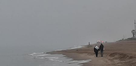 La niebla no evita que los ciudadanos lleven a cabo su paseo matinal.