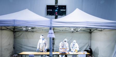 El pasado 14-F hubo elecciones autonomicas catalanas a pesar de la tercera ola por la pandemia coronavirus. Tres personas vestidas con EPIs en la mesa electoral del polideportivo la Sagrera, Barcelona