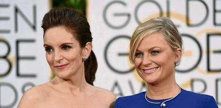 FILE - In this Jan. 11, 2015, file photo, Tina Fey, left, and Amy Poehler arrive at the 72nd annual Golden Globe Awards in Beverly Hills, Calif. The 78th Golden Globes will for the first time be held on two coasts, with Tina Fey live in New York and Amy Poehler in Beverly Hills, Calif., a person close to the show said Tuesday, Feb. 2, 2021, as the annual Hollywood ceremony adapts to the pandemic. (Photo by John Shearer/Invision/AP, File)