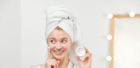 Chica poniéndose crema facial