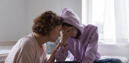 Worried parent young mom comforting depressed crying teen daughter bonding at home. Loving understanding mother apologizing or supporting sad teenage girl having psychological puberty problem concept.