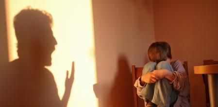 Aggressive parent. Father's shadow yelling on a small child. Child is in distress.