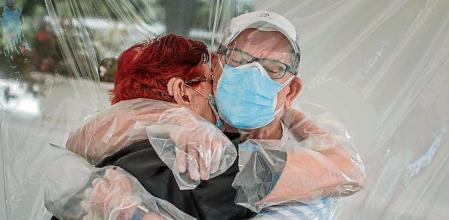 GRAFCVA5981. VALENCIA, 17/06/2020.- Una interna en una residencia de mayores abraza a su sobrino a través de un plástico habilitado para que los familiares se puedan dar su primer abrazo desde hace tres meses, debido al estado de alarma decretado por la pandemia del coronavirus. EFE/Biel Aliño