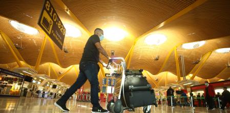 Un hombre camina con varias maletas en un carro en la terminal T4 del Aeropuerto Adolfo Suárez Madrid-Barajas, en Madrid 