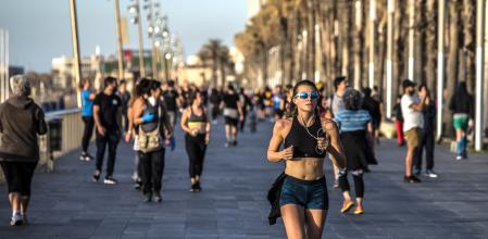 Una mujer practicando running en el paseo de la Barceloneta