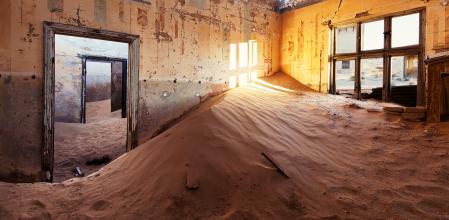 House in abandoned town of Kolmanskop, deserted diamond mining town in middle of dunes of Namib desert.