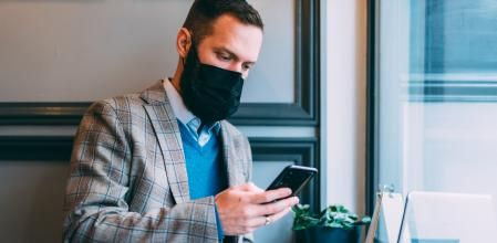Businessman in cafe is wearing mask for protection against coronavirus