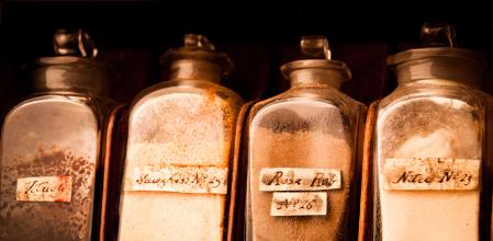 A wooden cabinet stocked with glass vials of healing potions, drugs, and medicines