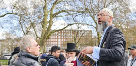 London, UK - April 17, 2016: Muslim fundamentalist preacher holding a Koran. Speakers Corner, Hyde Park, London England (London, UK - April 17, 2016: Muslim fundamentalist preacher holding a Koran. Speakers Corner, Hyde Park, London England, ASCII, 12