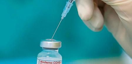 A nurse draws up the vaccine of the manufacturer Moderna against the coronavirus with a syringe in a posed situation a the vaccination centre in Bielefeld, Germany, Friday, April 16, 2021. (Friso Gentsch/dpa via AP)