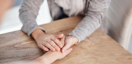 Closeup shot of two unrecognisable people holding hands in comfort