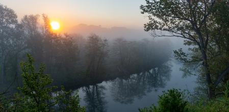 Sale el sol entre brumas en el río Ter.