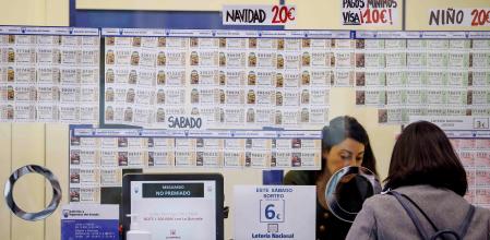 GRAFCVA354. VALENCIA, 12/12/2020.- Una persona adquire lotería cuando ya se ven colas en las administraciones más concurridas en las primeras semanas de diciembre, donde las ventas en ventanilla son 