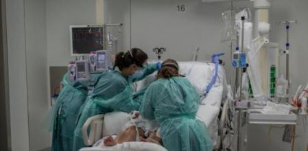 Sanitarias visitan a un enfermo ingresado en una de las habitaciones de la Unidad de Cuidados Intensivos –UCI- del Hospital de la Santa Creu i Sant Pau, integrado en la Red Hospitalaria de Utilización Pública de Catalunya, en Barcelona, Catalunya (España), a 6 de noviembre de 2020. Ahora que la región pasa por la segunda ola de la pandemia, la Consellería de Sanidad de Catalunya confirma que a día de hoy la red de unidades de cuidados intensivos (UCI) del sistema está al 87% de su capacidad y Catalunya ha registrado 290.244 casos confirmados acumulados de coronavirus. 06 NOVIEMBRE 2020;SANIDAD;SALUD;COVID-19;ENFERMO;UCI David Zorrakino / Europa Press 06/11/2020
