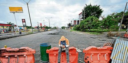 Demonstrators block a street with a barricade to protest against a tax reform bill launched by President Ivan Duque, in Cali, Colombia, on May 3, 2021. - At least 17 people died and more than 800 were wounded in clashes that broke out in Colombia during five days of protests against a proposed government tax reform, authorities said on Monday. (Photo by Luis ROBAYO / AFP)