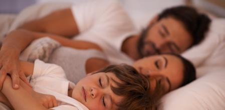 Cropped shot of a young family in bed together