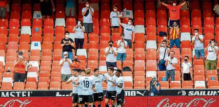 VALENCIA, 16/05/2021.- Aficionados del Valencia CF celebran el cuarto gol del equipo ante el Eibar, durante el partido de Liga en Primera División que disputan este domingo en el estadio Mestalla de Valencia. EFE/Biel Aliño