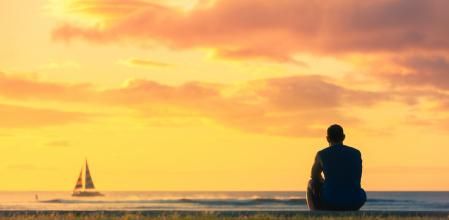 Men watching the sunrise at the beach. Location Hawaii.