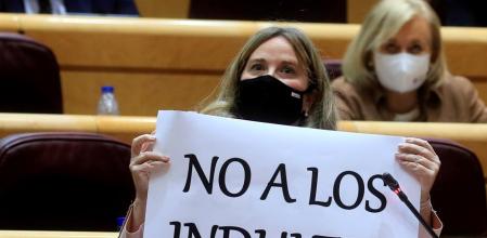 La senadora del PP, Cristina Ayala, enseñó al ministro de Justicia carteles contra los indultos, durante la sesión de control al Gobierno