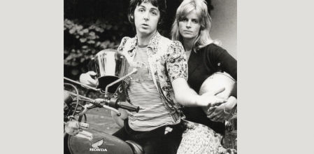 Paul McCartney sentado sobre una Honda junto a su mujer, Linda