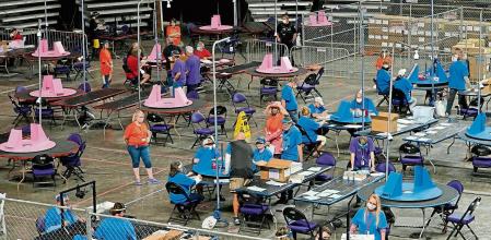 FILE - In this May 6, 2021 file photo, Maricopa County ballots cast in the 2020 general election are examined and recounted by contractors working for Florida-based company, Cyber Ninjas at Veterans Memorial Coliseum in Phoenix. On Friday, May 21, The Associated Press reported on stories circulating online incorrectly claiming the election database in Maricopa County, in Arizona has been deleted, seals were improperly broken on boxes that hold the votes and ballots are missing.(AP Photo/Matt York, Pool, File)