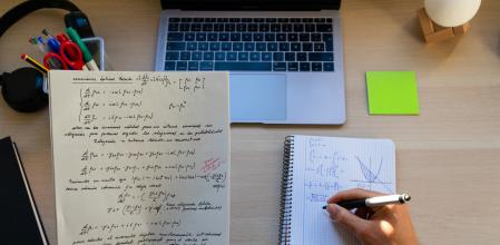 top view of high school or college student studying and doing exercises on a desk with a laptop