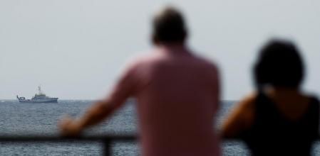 People watch as the Spanish vessel Angeles Alvarino carries out a search operation to try to locate a second missing girl and her father, near the coast of the Spanish island of Tenerife, Spain, June 11, 2021. REUTERS//Borja Suarez