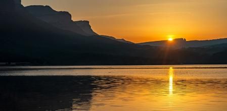 El pantano de Sau con el sol al fondo.
