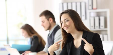 Proud businesswoman pointing himself at office