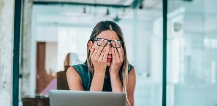 Shot of a stressed businesswoman with headache in the office.