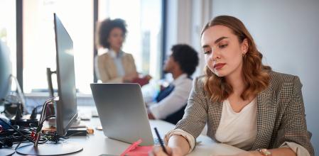 young business woman writing down reminder on a sticky note