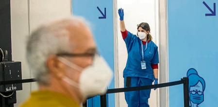 Vacunacion masiva en Fira Montjuic a la población con vacuna Astrazeneca. Una enfermera llamando a un ciudadano para que entre en un box a vacunarse