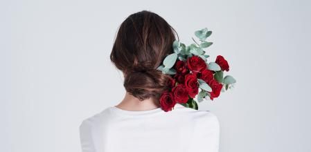 Studio shot of an unrecognizable woman holding flowers against a grey background