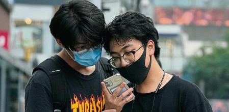 Men look at a smartphone in Beijing on Monday, July 5, 2021. Days after China's largest ride-hailing app Didi Global Inc. went public in New York as the biggest Chinese IPO in the U.S. since Alibaba's 2014 listing, Chinese regulators clamped down on the firm, ordering it to halt new registrations and remove its app from China's app stores while the company undergoes a cybersecurity review. (AP Photo/Ng Han Guan)