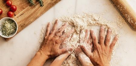 Little girl kneading flour with her mother. Infant Chef Concept.