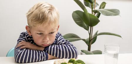 Spoiled kid does not want to eat his diner with vegetables