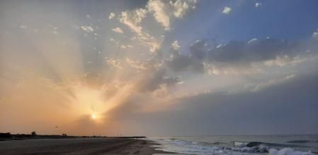 Rayos crepusculares en el amanecer en la playa de Gavà.