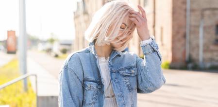 Portrait of young blonde girl with disheveled hair on a city street