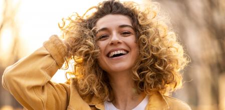 Portrait of young woman with curly hair in the city